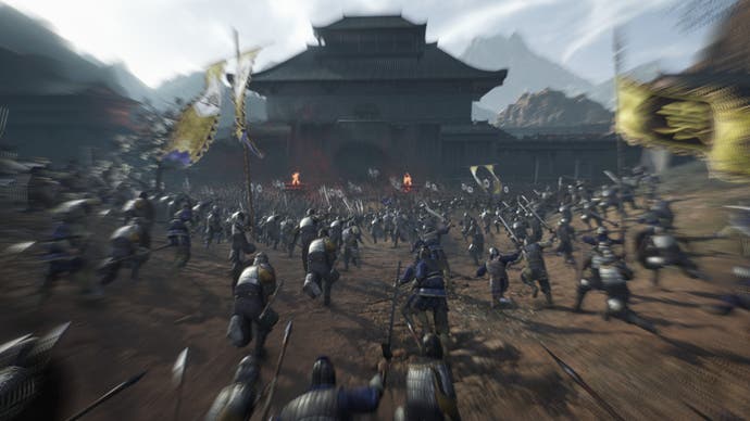 Dynasty Warriors: Origins screenshot of an army of foot soldiers charging towards a castle.