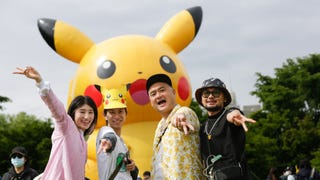 Pokémon Go Fest players beside a giant inflatable Pikachu.